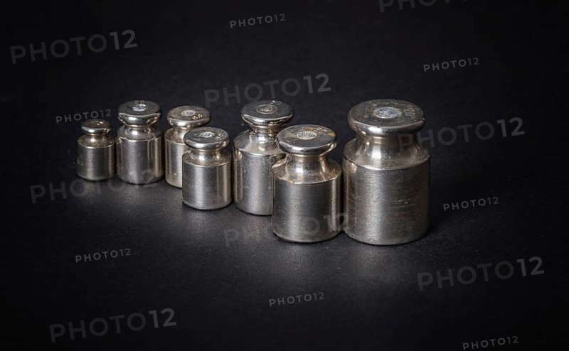A set of small metal weights on a gray background