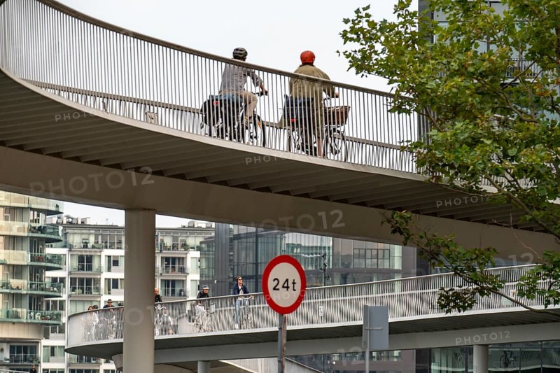 Cyclists on the Cykelslangen cycle and pedestrian bridge, at the Fisketorvet shopping centre, across the harbour, Sydhavnen, Copenhagen is considered the cycling capital of the world, 45 % of the population travel by bike, Denmark, Europe