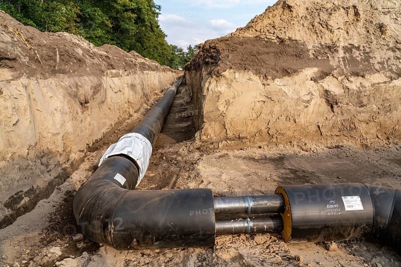 Laying of district heating pipes, next to a field, with maize, the district heating comes from a biogas plant and is fed directly into households in the neighbourhood, private provider, near Delbrück, North Rhine-Westphalia, Germany, Europe