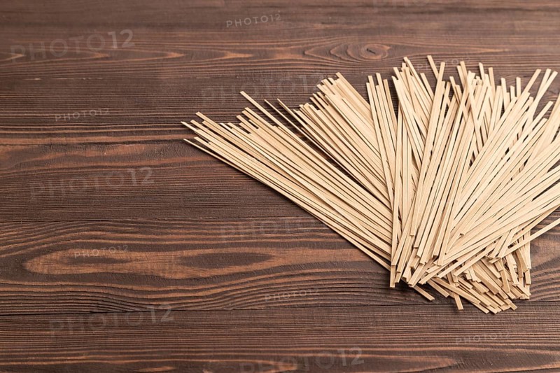 Japanese buckwheat soba noodles on brown wooden background. Side view, copy space