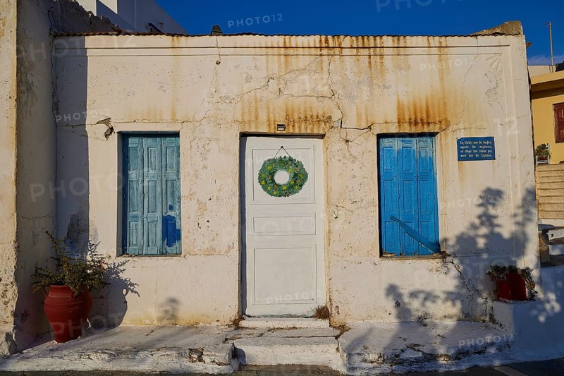 Traditional house with blue shutters and a white door with wreath, Pyles village, west coast, Karpathos, Dodecanese, Greek Islands, Greece, Europe