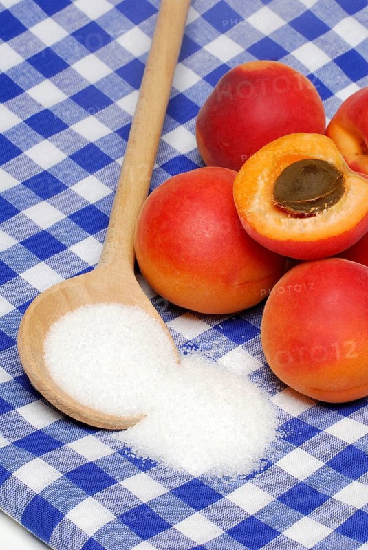 Apricots ( Prunus armeniaca) , Cooking spoon with sugar