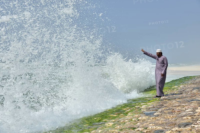 Local man watching the surf at the corniche of Salalah during the monsoon season, or Khareef season, Salalah, Dhofar region, Orient, Oman, Asia
