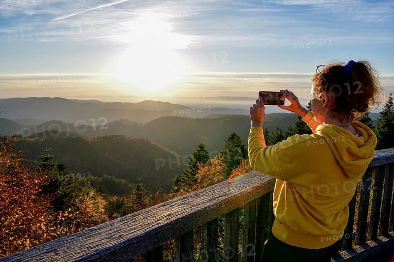 Woman photographing the sunset at Schliffkopf, near Baiersbronn, Freudenstadt district, Black Forest, Baden-Württemberg, Germany, Europe