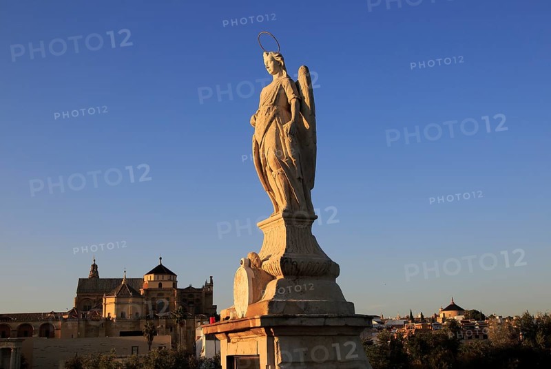 Angel San Rafael statue on Roman bridge Cordoba, Spain with view towards the cathedral