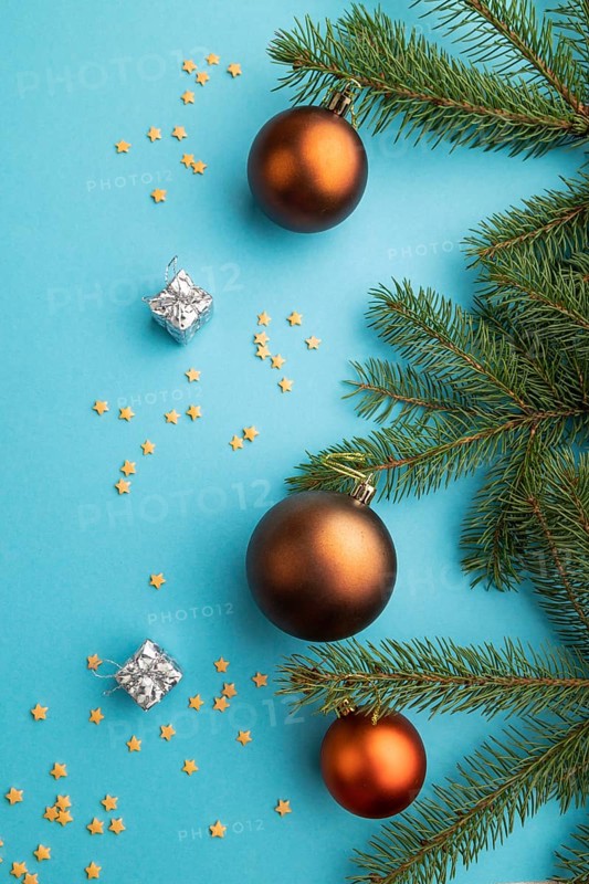 Christmas or New Year composition. Decorations, bronze balls, fir and spruce branches, on a blue paper background. Top view, close up, flat lay