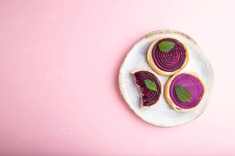 Sweet tartlets with jelly and milk cream on a pastel pink background. top view, flat lay, copy space