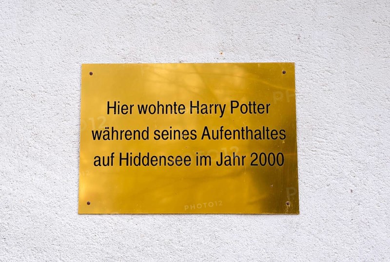 A golden plaque on a wall marking Harry Potter's stay in Hiddensee in 2000, joking sign, plaque on a white wall, village of Kloster, Hiddensee Island, Baltic Sea, Germany, Europe