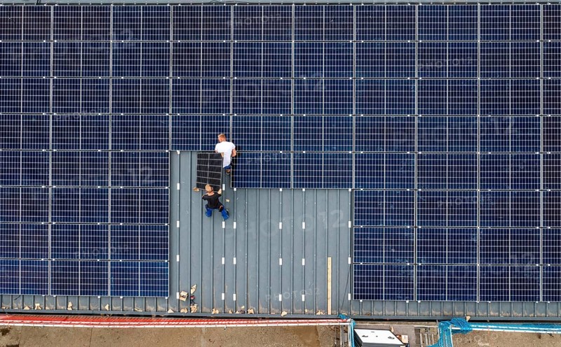 Installation of solar modules on the roof of a barn on a farm, over 210 photovoltaic modules are installed on the roof, North Rhine-Westphalia, Germany, Europe