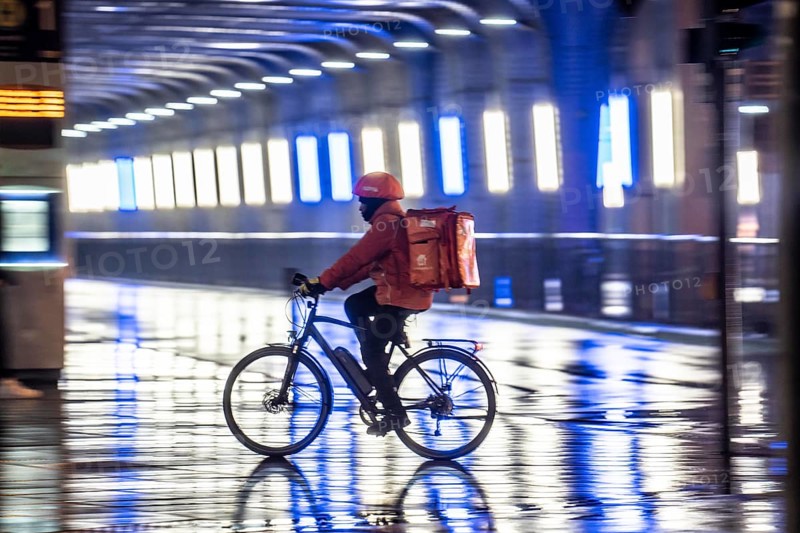 Street at the main station, Lieferando courier, cyclist, rainy weather, city centre, in the evening, Essen, North Rhine-Westphalia, Germany, Europe