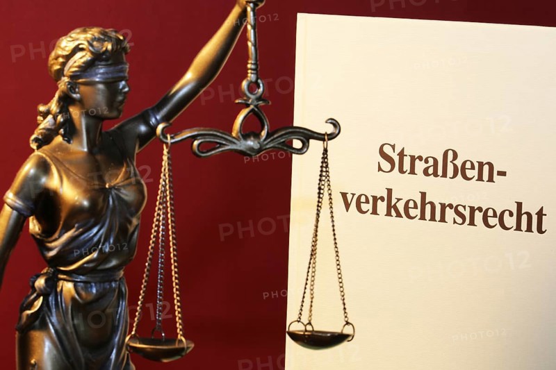 Symbolic image: Textbook on traffic law and a Justitia