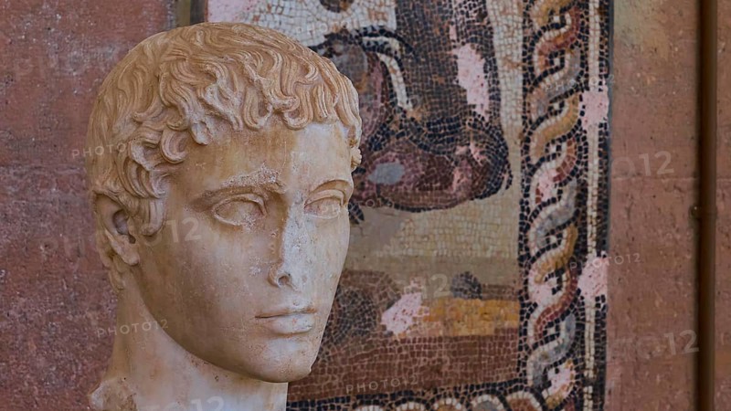 Classical portrait of an ancient marble bust, head of a young man, against a mosaic background, Archaeological Museum, Archea Korinthos, Corinth, Peloponnese, Greece, Europe