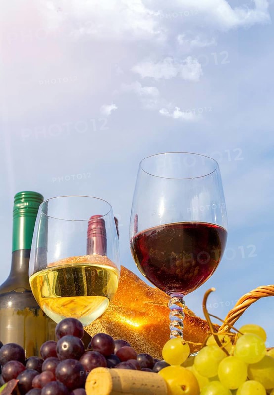 Symbolic image: Ripe grapes decorated with wine glasses on a wooden table