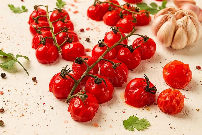 Baked branch, mini, cherry tomatoes, with spices and herbs, garlic, food background, top view, on a white background