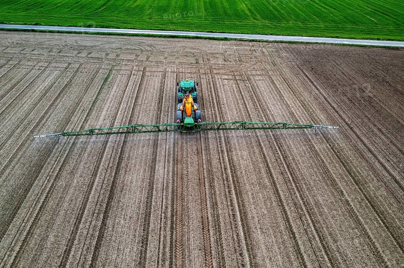 Farmer working a field, crop protection agent being sprayed, field with young sugar beet plants, North Rhine-Westphalia, Germany, Europe