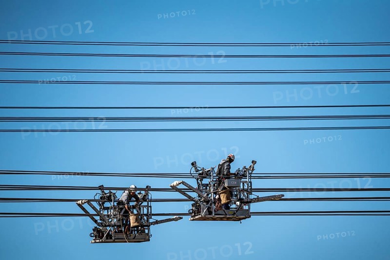Construction of a new line route, 380 KV extra-high-voltage line between Osterath and Gohr, near Neuss, fitters in line trolleys, on the conductor cables, installing field spacers at great heights, North Rhine-Westphalia, Germany, Europe