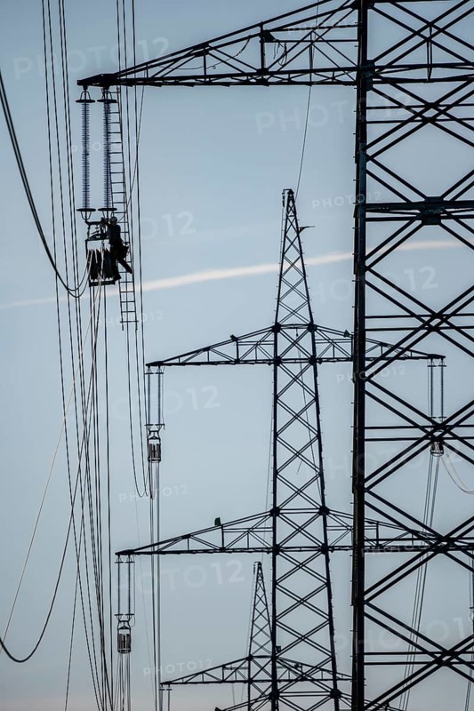 Construction of a new line route, 380 KV extra-high voltage line between Osterath and Gohr, near Neuss, fitter on ladder at great height, tensioning the lines, North Rhine-Westphalia, Germany, Europe