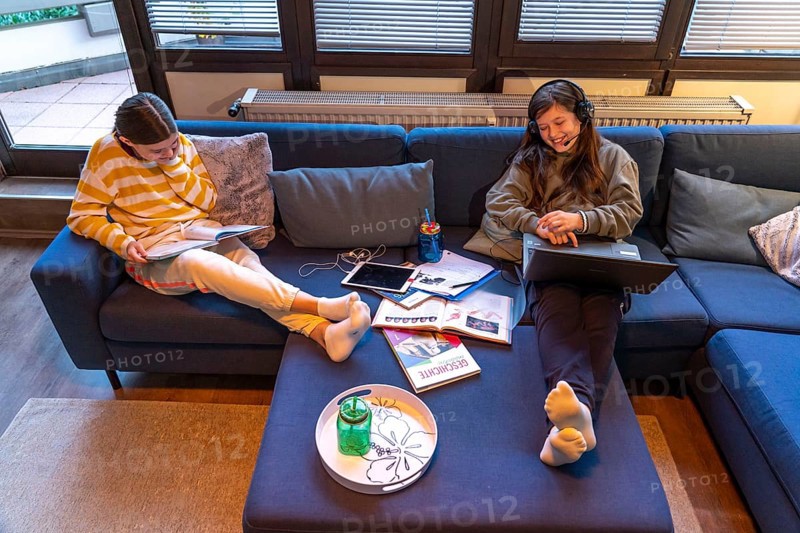 Homeschooling, 2 girls, sisters, 11 years old, learning at home, home learning, lessons at home, distance learning, chat with teachers and classmates via laptop, tablet PC, symbolic image