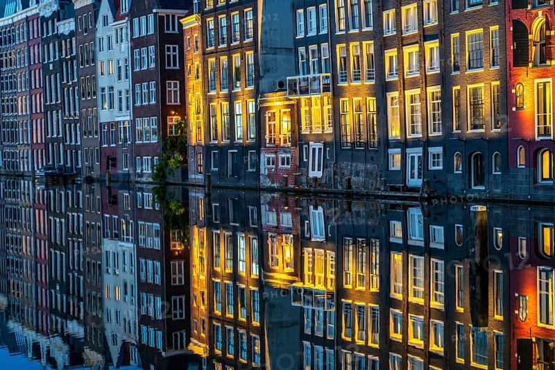 Canal houses on the Damrak, in the centre of the old town of Amsterdam, harbour, starting point of many canal tours, evening, Netherlands