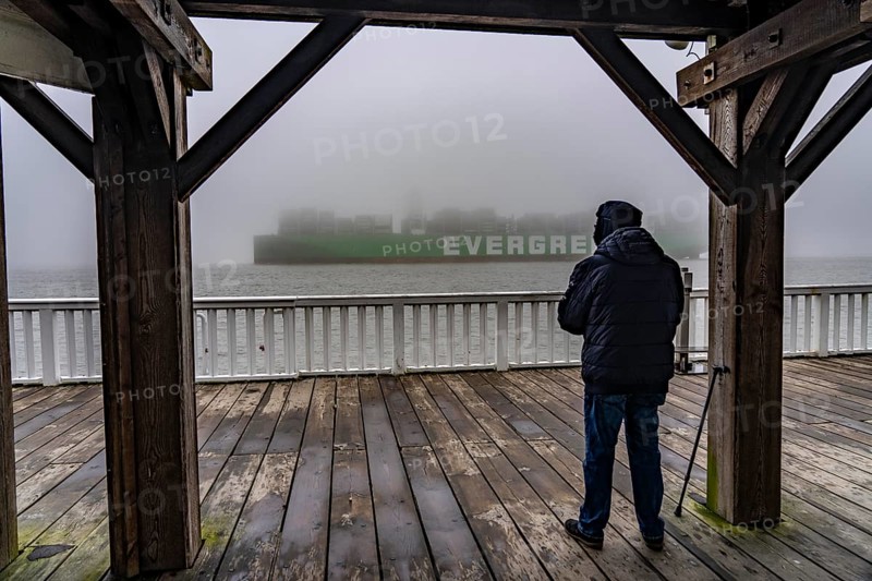 Thick fog in winter, hanging over the mouth of the Elbe into the North Sea, container ship Ever Arm, leaving the Elbe for Rotterdam, viewpoint Alte Liebe in Cuxhaven, Lower Saxony, Germany, Europe