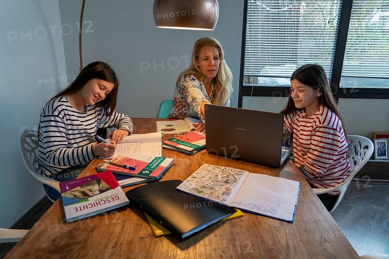 Homeschooling, during the lockdown in January 2021, mother helps her two daughters, at home, learning, with textbooks and computers, school closures, distance learning, effects of the corona crisis in Germany