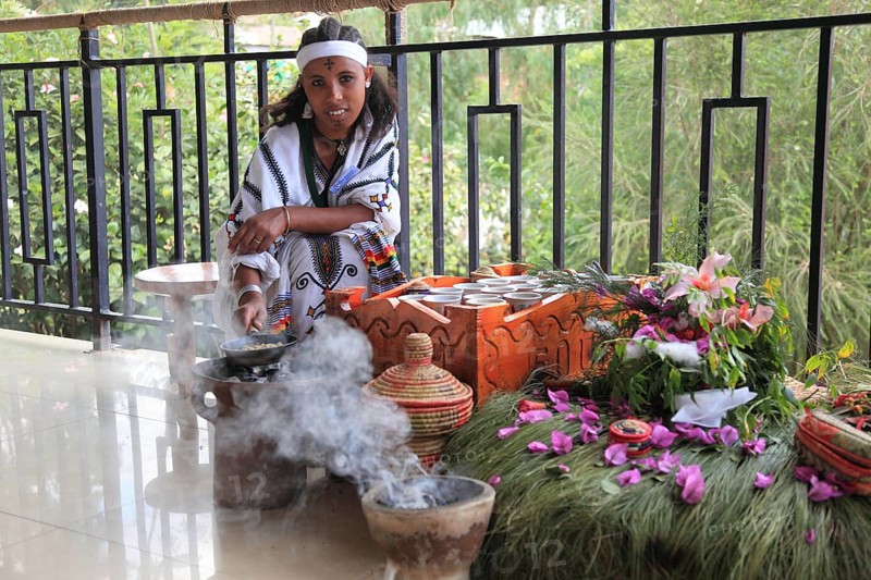 Attractive young woman, traditional coffee ceremony in a restaurant, roasting coffee beans and smoking with perfumes, Ethiopian, Ethiopia, Africa