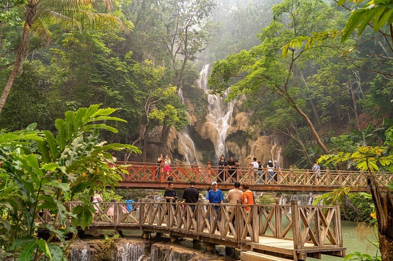 Tourists on the bridge at Kuang Si waterfall near Luang Prabang, Laos, Asia
