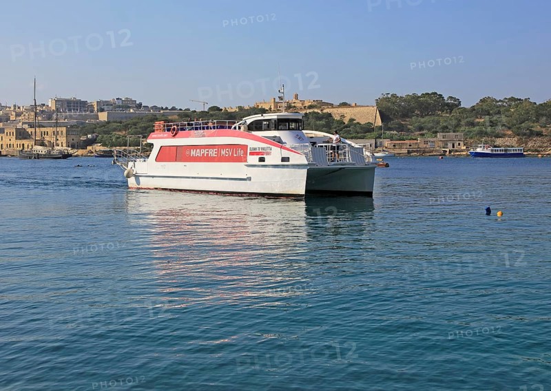Mapfre Topcat ferry boat crossing harbour from Valletta to Sliema, Malta passing Fort Manoel