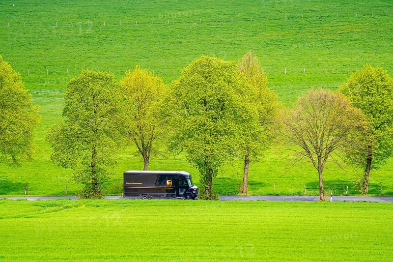 UPS delivery van on a country road, green fields, meadows, trees line the 2-lane road, spring, near Schwelm, North Rhine-Westphalia, Germany, Europe