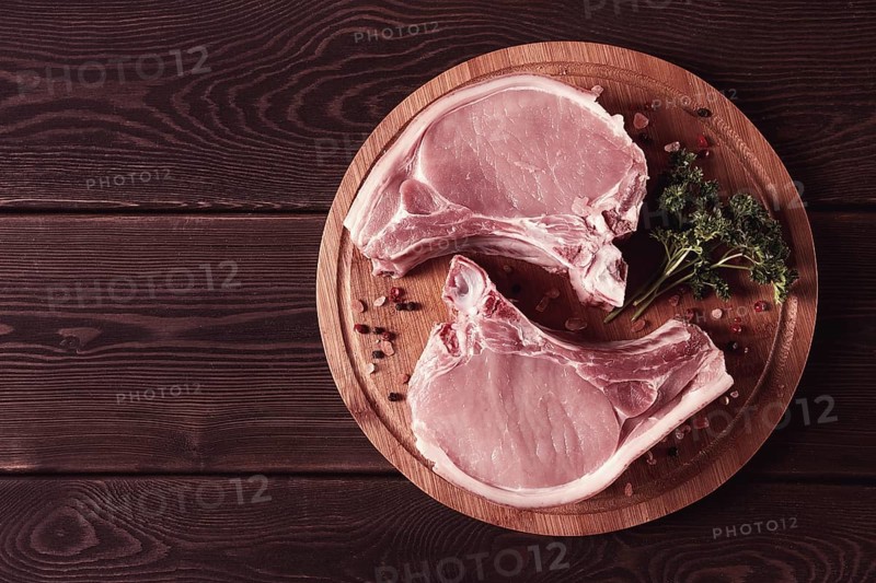 Fresh, raw pork meat, sliced, on a cutting board, with spices, horizontal, rustic style, toning, no people