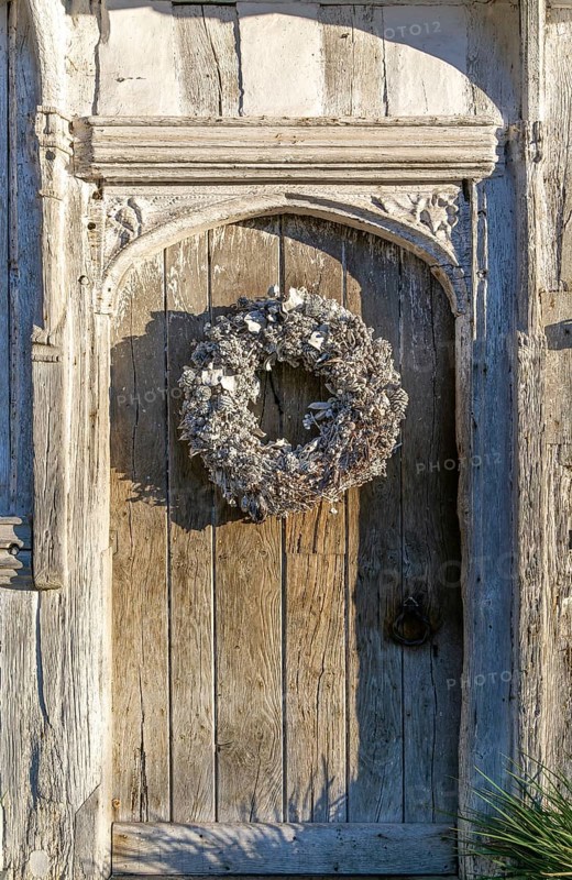 Silver white Christmas wreath on ancient old door in Lavenham, Suffolk, England, UK