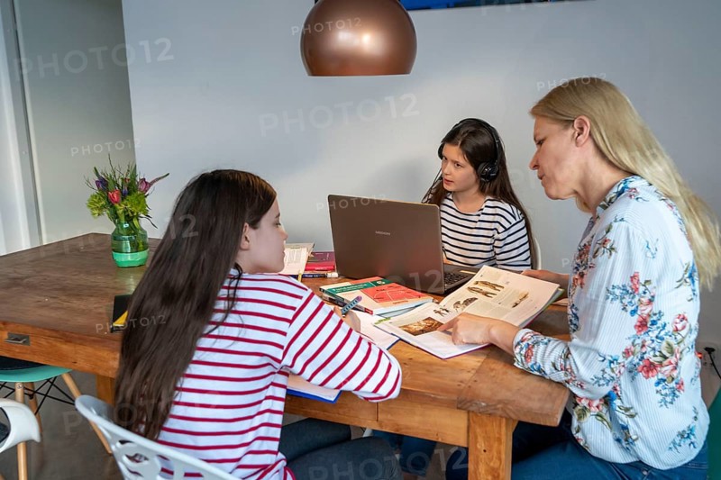 Homeschooling, during the lockdown in January 2021, mother helps her two daughters, at home, learning, a girl is in video lessons with her class, school closures, distance learning, effects of the corona crisis in Germany