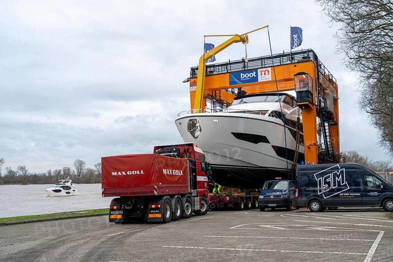 Craning the €6.3 million Sunseeker 88Y motor yacht, weighing 82 tonnes, in preparation for the world's largest water sports trade fair, Boot in Düsseldorf, luxury yachts are driven across the Rhine to the trade fair and brought ashore with the help of the Big Willi ship crane and transported to the exhibition halls on a low-loader, North Rhine-Westphalia, Germany, Europe