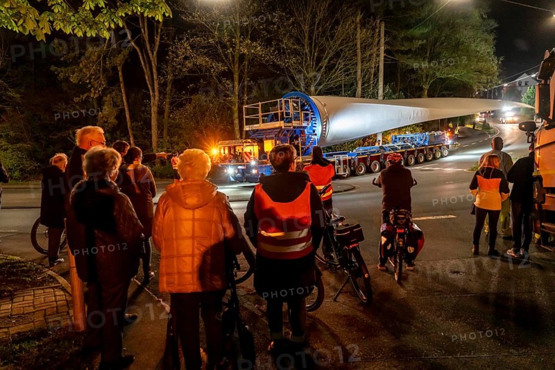 Transport of a 68 metre long, 22 tonne blade of a wind turbine, here in Schwelm, onlookers, with a self-propelled Blade-Lifter vehicle, over a 40 km long route, over 2 nights, in the Bergisches Land, through towns, villages, over country roads, narrow through roads, to the construction site of the wind turbine near Hagen, North Rhine-Westphalia, Germany, Europe