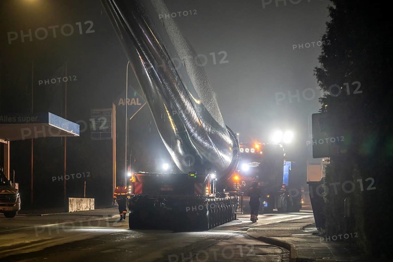 Transport of a 68 metre long, 22 tonne blade of a wind turbine, here in Breckerfeld, with a self-propelled Blade-Lifter vehicle, over a 40 km long route, over 2 nights, in the Bergisches Land, through towns, villages, over country roads, narrow through roads, to the construction site of the wind turbine near Hagen, North Rhine-Westphalia, Germany, Europe