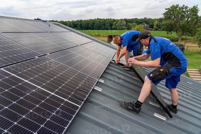 Installation of solar modules on the roof of a barn on a farm, over 240 photovoltaic modules are installed on the roof, North Rhine-Westphalia, Germany, Europe