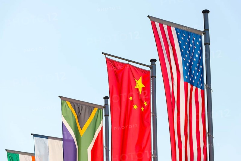 Various national flags fly on flagpoles against a blue sky, Chinese flag, American flag