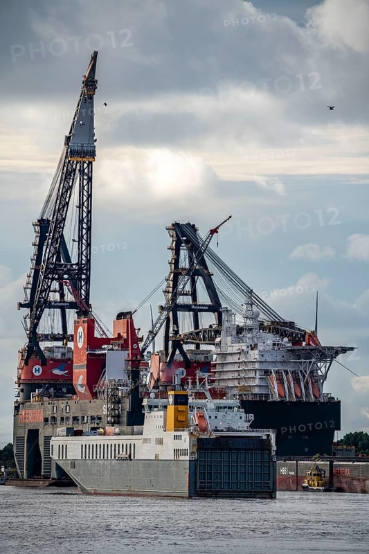 Petroleum harbour, Roro ferry at the exit, behind it the largest floating crane in the world, Heerema Sleipnir, from Rotterdam, Netherlands