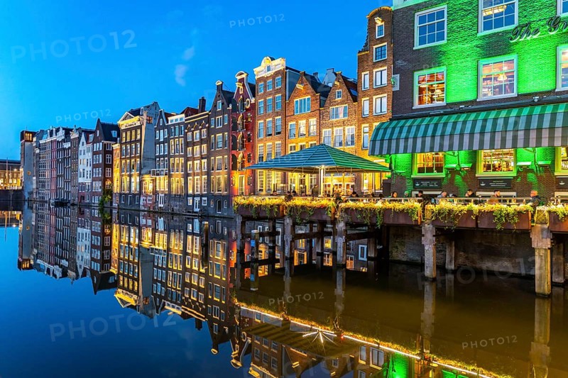 Canal houses on the Damrak, in the centre of the old town of Amsterdam, harbour, starting point of many canal tours, evening, Netherlands