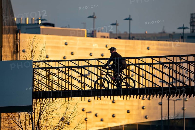 Cyclist on a bridge over Segerothstraße, in Essen, behind Limbecker Platz shopping centre