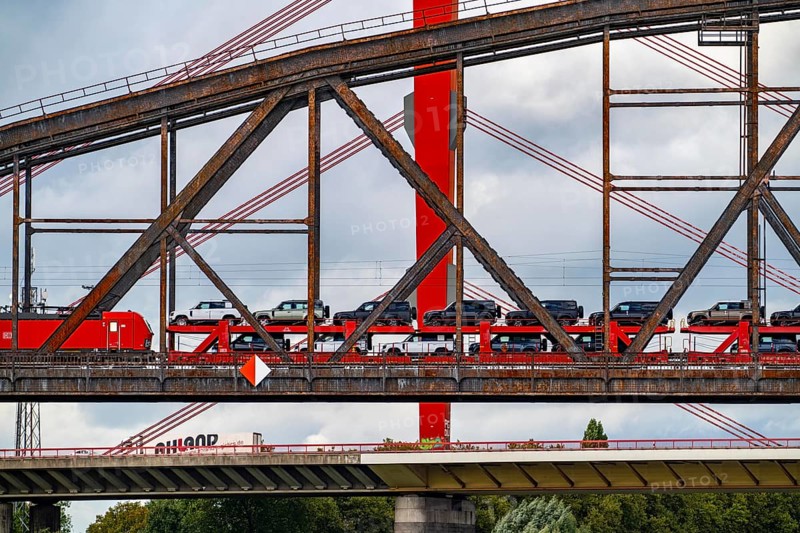 The Beeckerwerther Rhine bridge of the A42 motorway, truck traffic, in front of it the Haus-Knipp railway bridge, goods train, car train, new car of the type, Land Rover Defender, Rhine near Duisburg, North Rhine-Westphalia, Germany, Europe