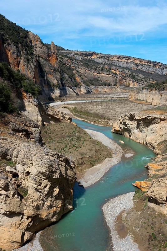 A winding river flows through a rocky gorge in a mountainous landscape under a clear sky, Noguera Ribagorçana Mont-rebei Natural Park, Montsec mountain range, Noguera Ribagorçana river, Lleida province, Catalonia, Aragon, Spain, Europe