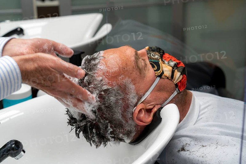 Hairdressing salon in Essen-Rüttenscheid, first customer after 6 weeks, shop closed due to Corona, hairdresser and customer with mouth-nose protection, breathing mask, Plexiglas protective walls, spit protection, when washing hair, distance regulation, Essen, North Rhine-Westphalia, Germany, Europe