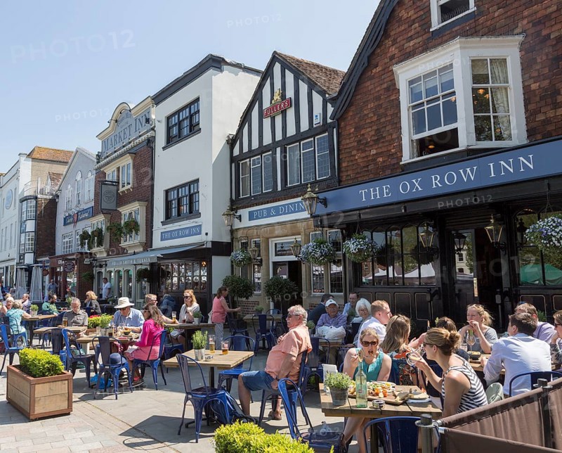 People sitting outside Ox Row Inn and Market Inn on sunny day, Market Place, Salisbury, Wiltshire, England, UK