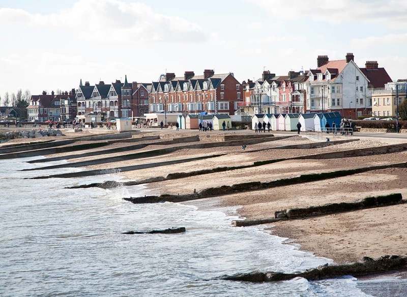 Sandy beach concrete groyne sea defences and historic buildings on the seafront on a sunny day in winter at Felixstowe, Suffolk, England, United Kingdom, Europe