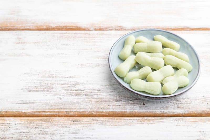 Jelly celery candies on white wooden background. copy space, side view, close up