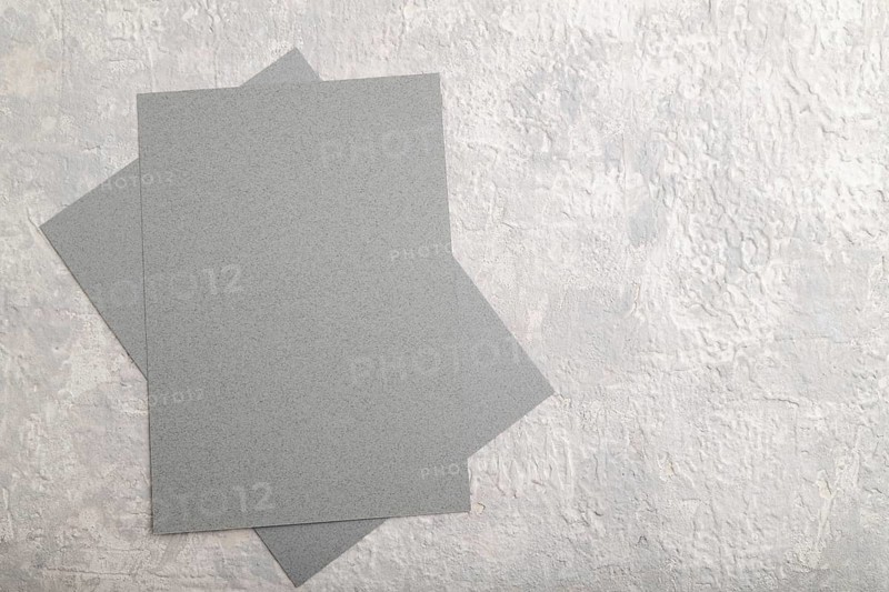 Gray paper business card, mockup on gray concrete background. Blank, flat lay, top view, still life, copy space