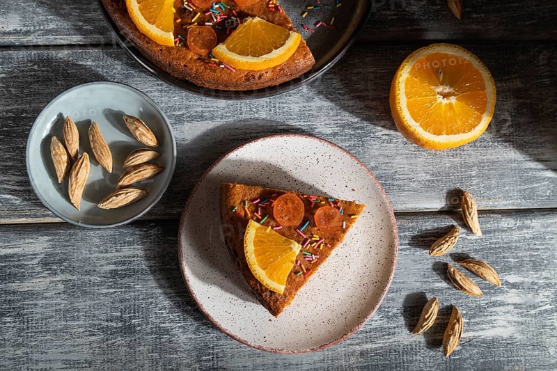 Orange cake on a gray wooden background. Hard light. contrast, low key. Top view, flat lay, close up