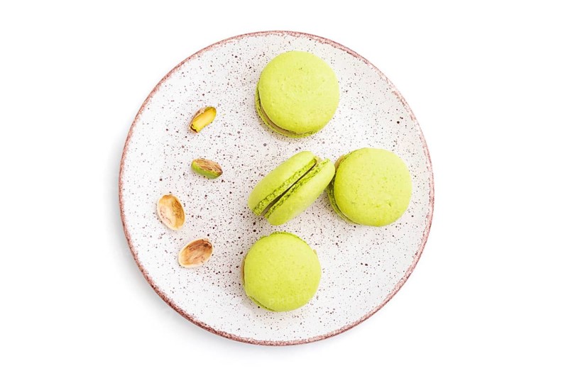 Green macarons or macaroons cakes isolated on white background. Top view, close up