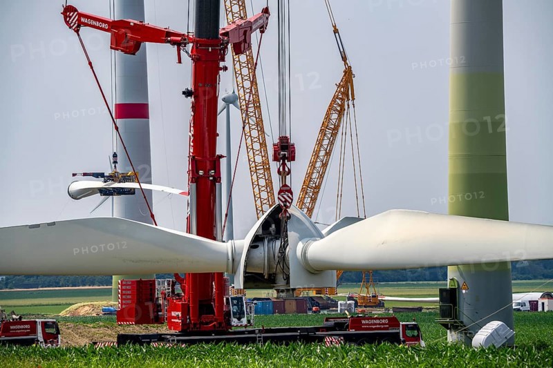 Dismantling of a wind power plant in a wind farm near Issum, 9 older wind turbines from the manufacturer Enercon (model series E-58), front, blades being dismantled, were in operation for over two decades, will be replaced by a total of four Enercon E-160 turbines, rear, assembly of the first blade, with a total output of 22 megawatts, Lower Rhine, North Rhine-Westphalia, Germany, Europe